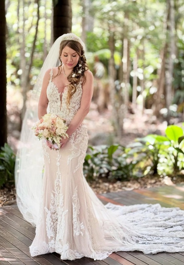 Bride in full lace gown and veil, outdoor forest setting